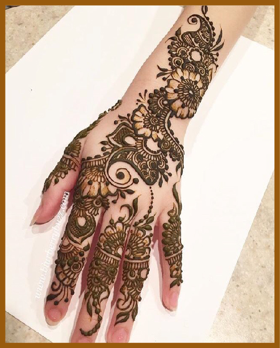 Stylish back hand bridal mehndi with thick trails Stylish back hand bridal mehndi with thick trails