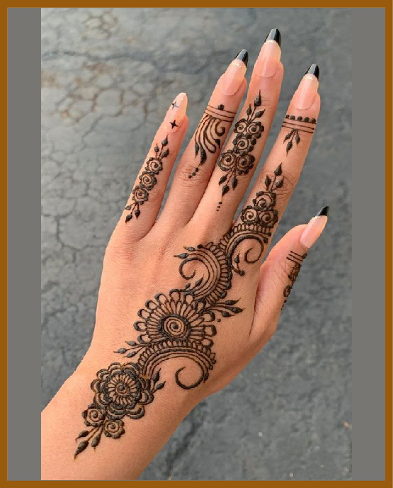 Aesthetic mehndi design for back hand with curled vines and floral touches Aesthetic mehndi design for back hand with curled vines and floral touches