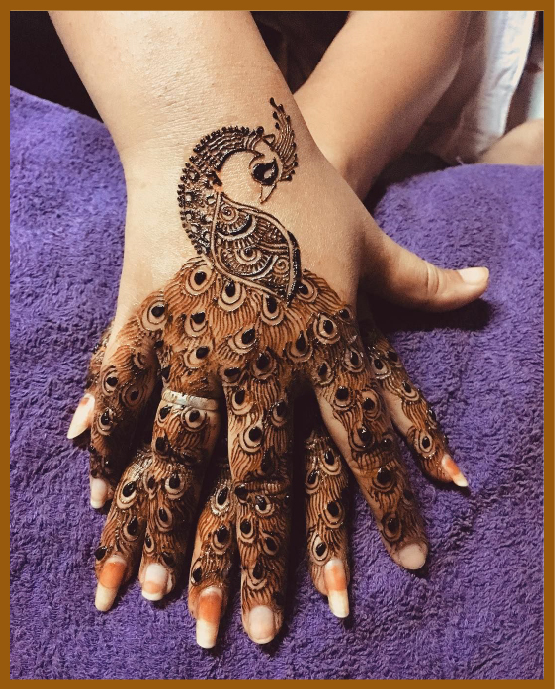 Artistic back hand mehndi with peacock motif Artistic back hand mehndi with peacock motif