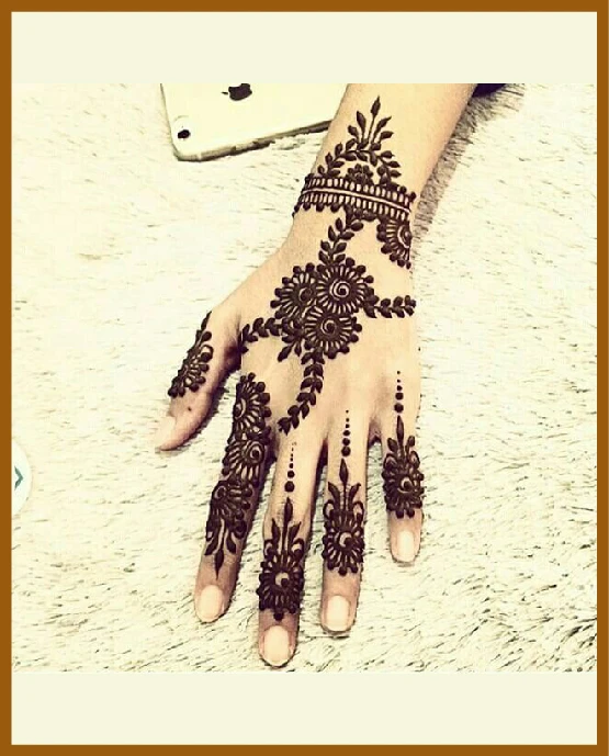 Floral curls and chain trail in modern back hand mehndi design Floral curls and chain trail in modern back hand mehndi design